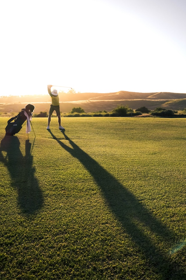 Person slår ett golfslag på banan